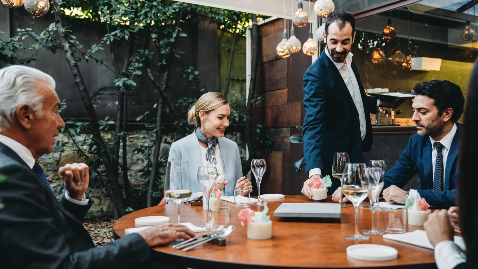 Colleagues enjoying a meal at an elegant high-end restaurant during a meeting